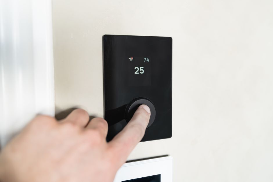 Hand adjusting a smart home thermostat