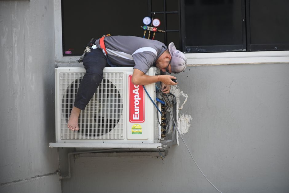 HVAC technician repairing an air conditioning unit